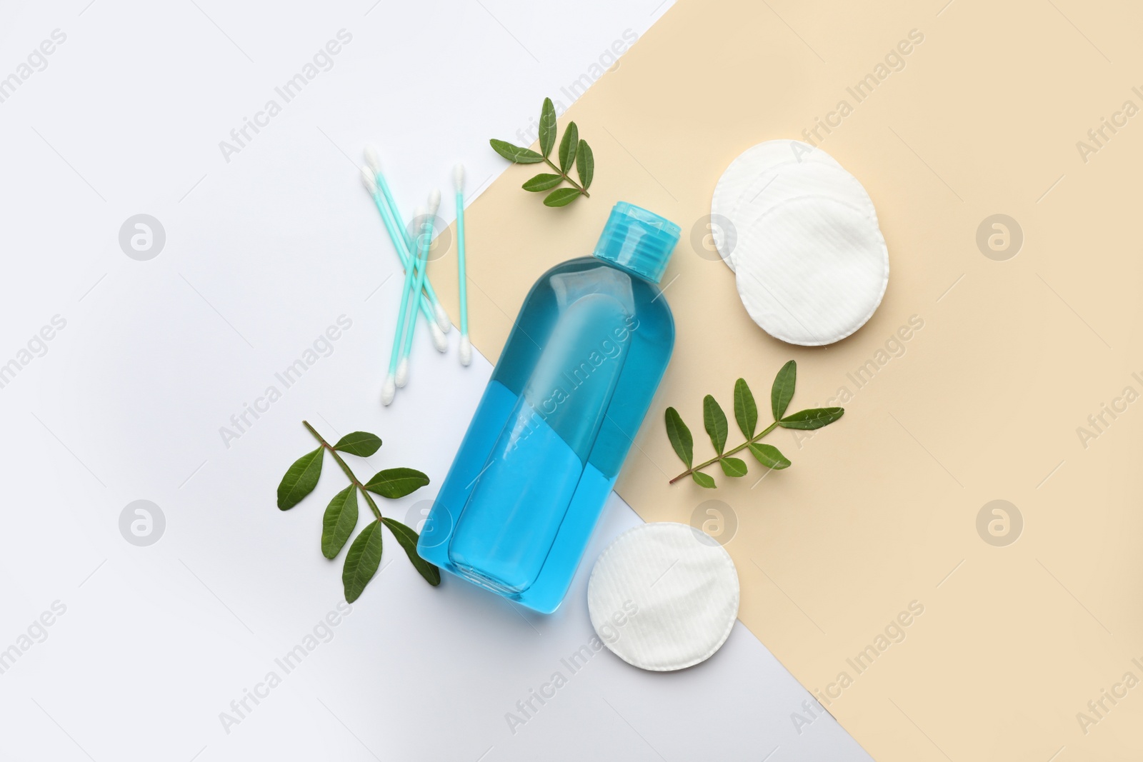 Photo of Cotton pads, swabs, leaves and makeup removal product on color background, flat lay