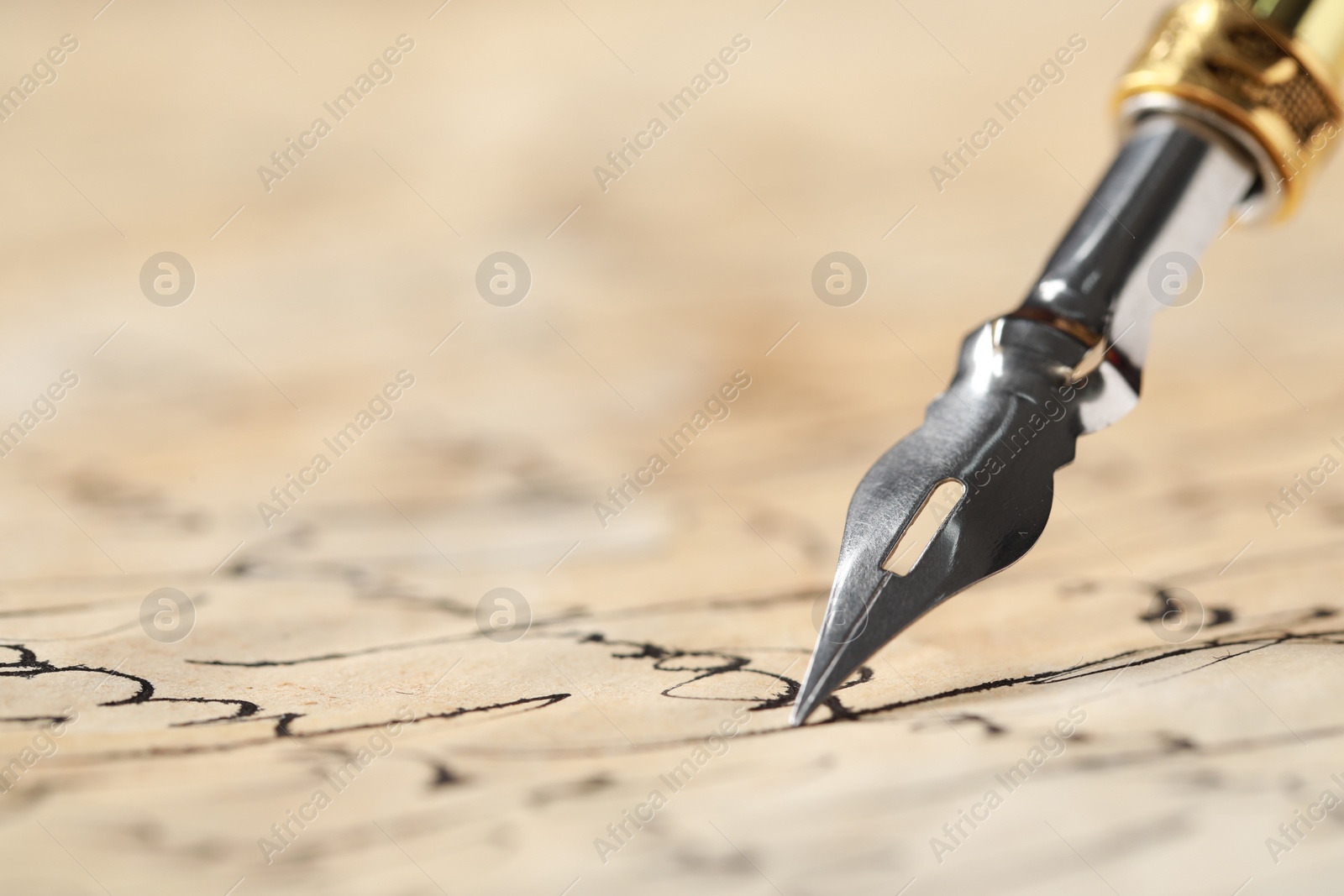 Photo of Writing with fountain pen on vintage parchment, closeup. Space for text