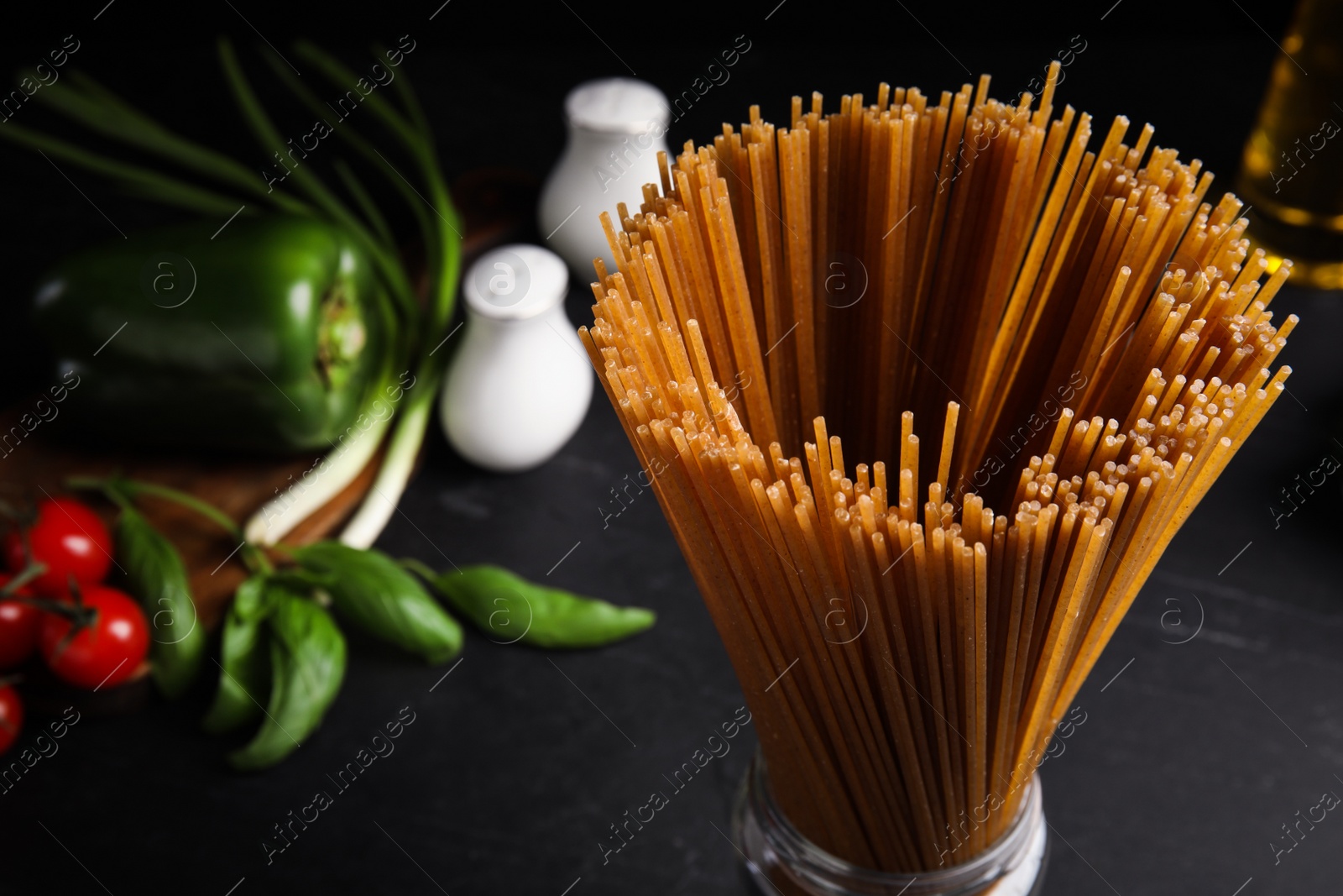 Photo of Uncooked buckwheat noodles on black table, closeup