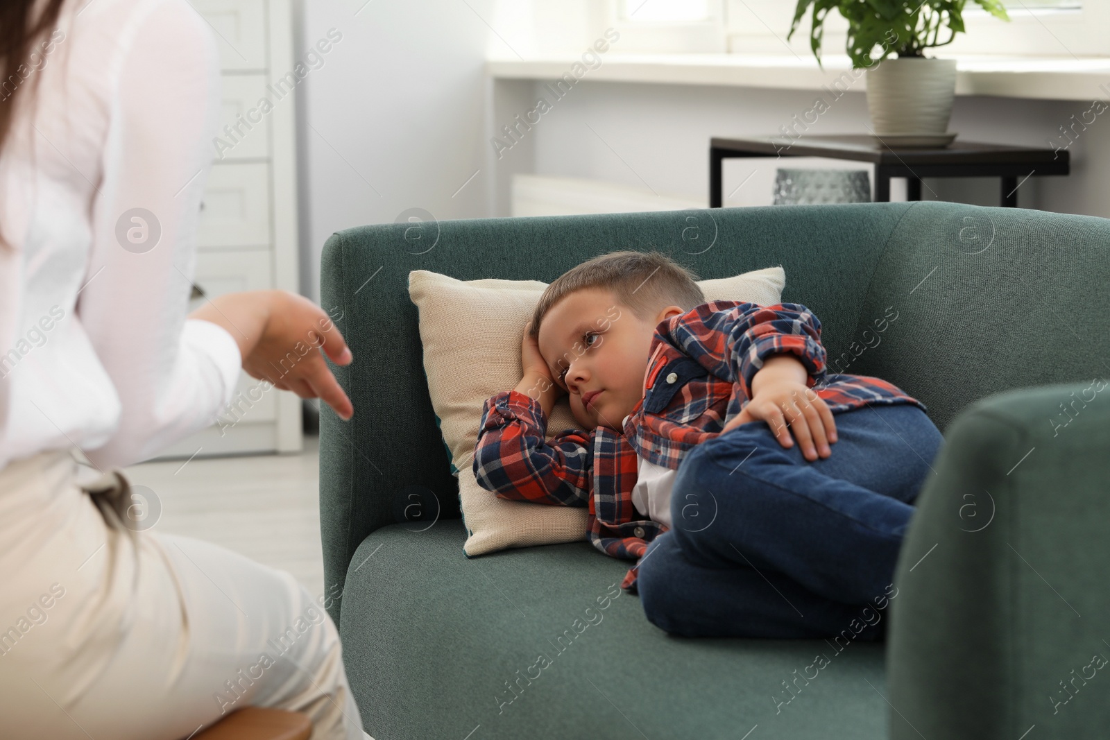 Photo of Psychologist working with unhappy little boy in office. Mental health problems