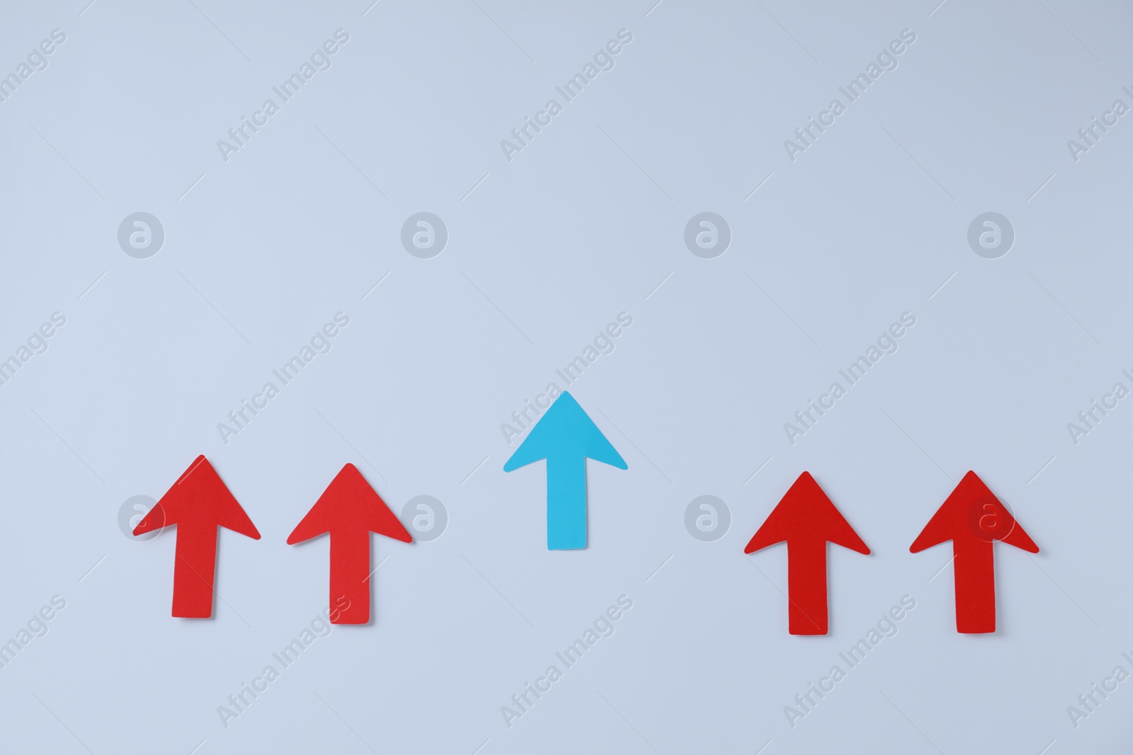 Photo of Red and light blue paper arrows on white background, flat lay. Space for text