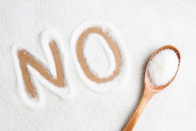 Word No made of sugar and wooden spoon on brown background, flat lay