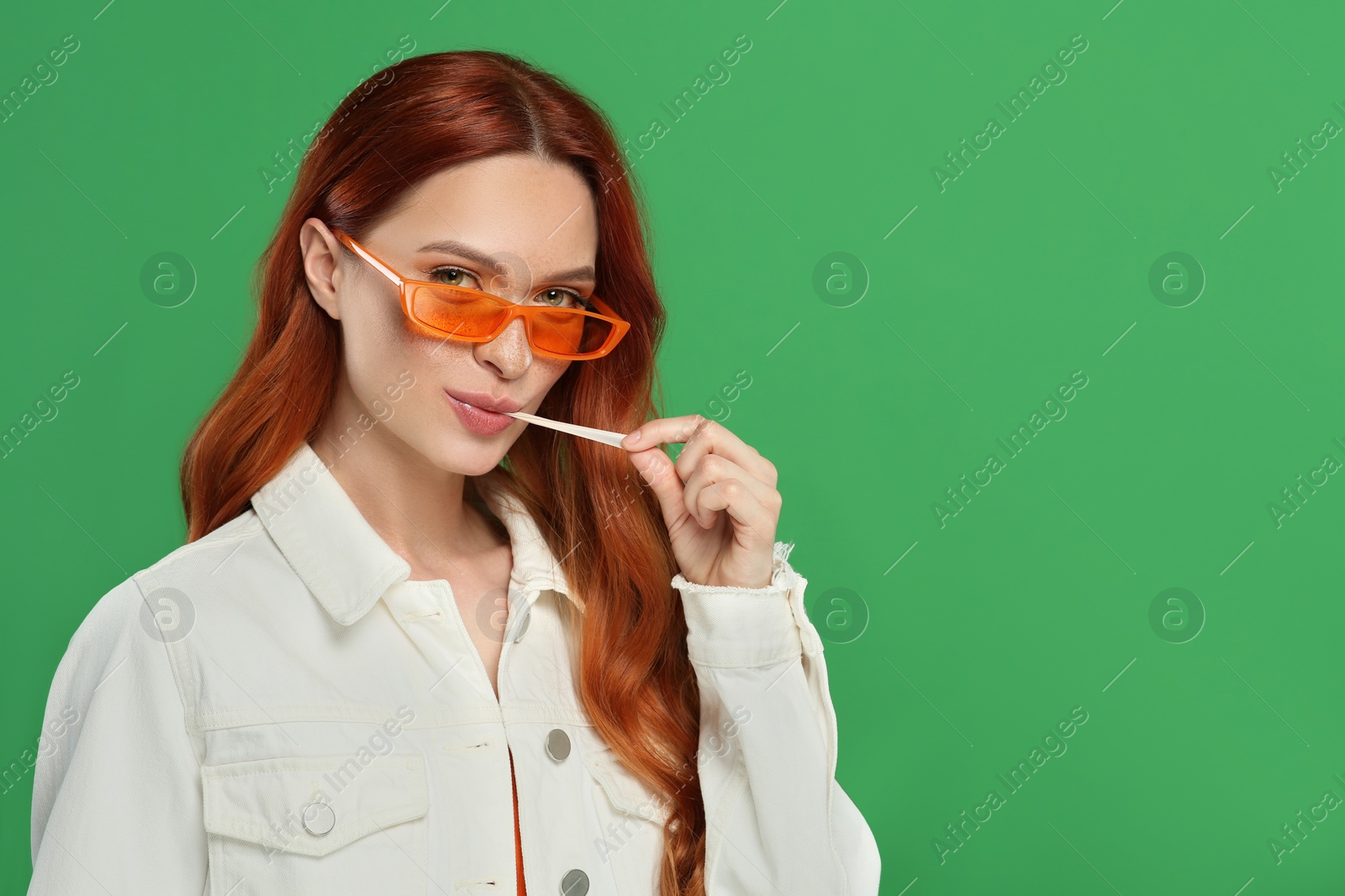 Photo of Portrait of beautiful woman in sunglasses with bubble gum on green background. Space for text