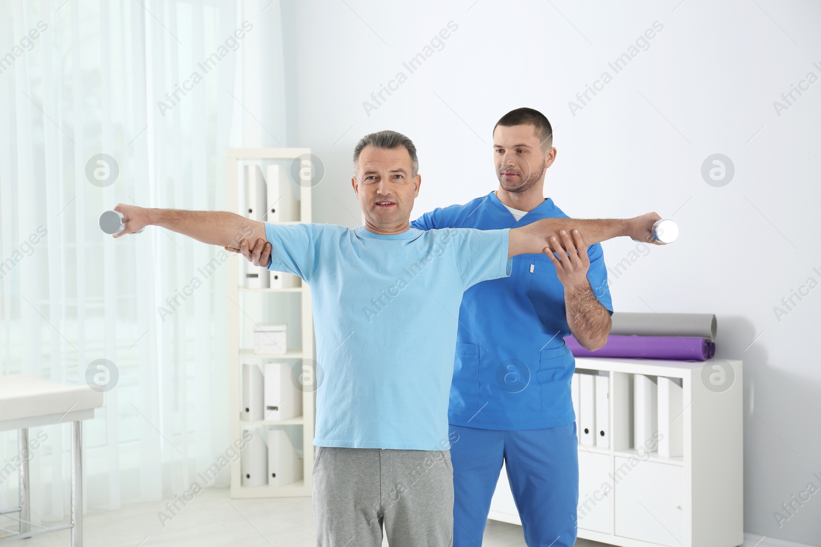 Photo of Doctor working with patient in hospital. Rehabilitation exercises