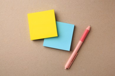Photo of Blank paper notes and pen on beige background, flat lay