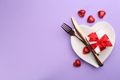 Photo of Beautiful table setting on violet background, flat lay with space for text. Valentine's Day dinner