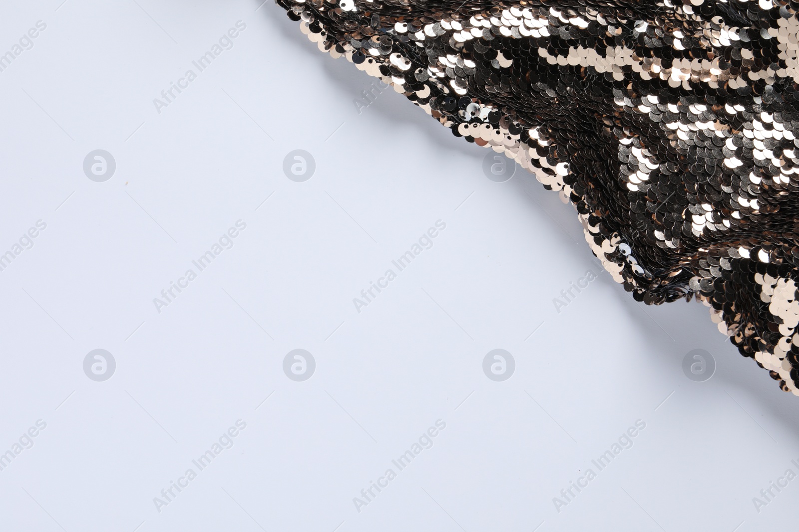 Photo of Beautiful golden sequin fabric on white background. Space for text