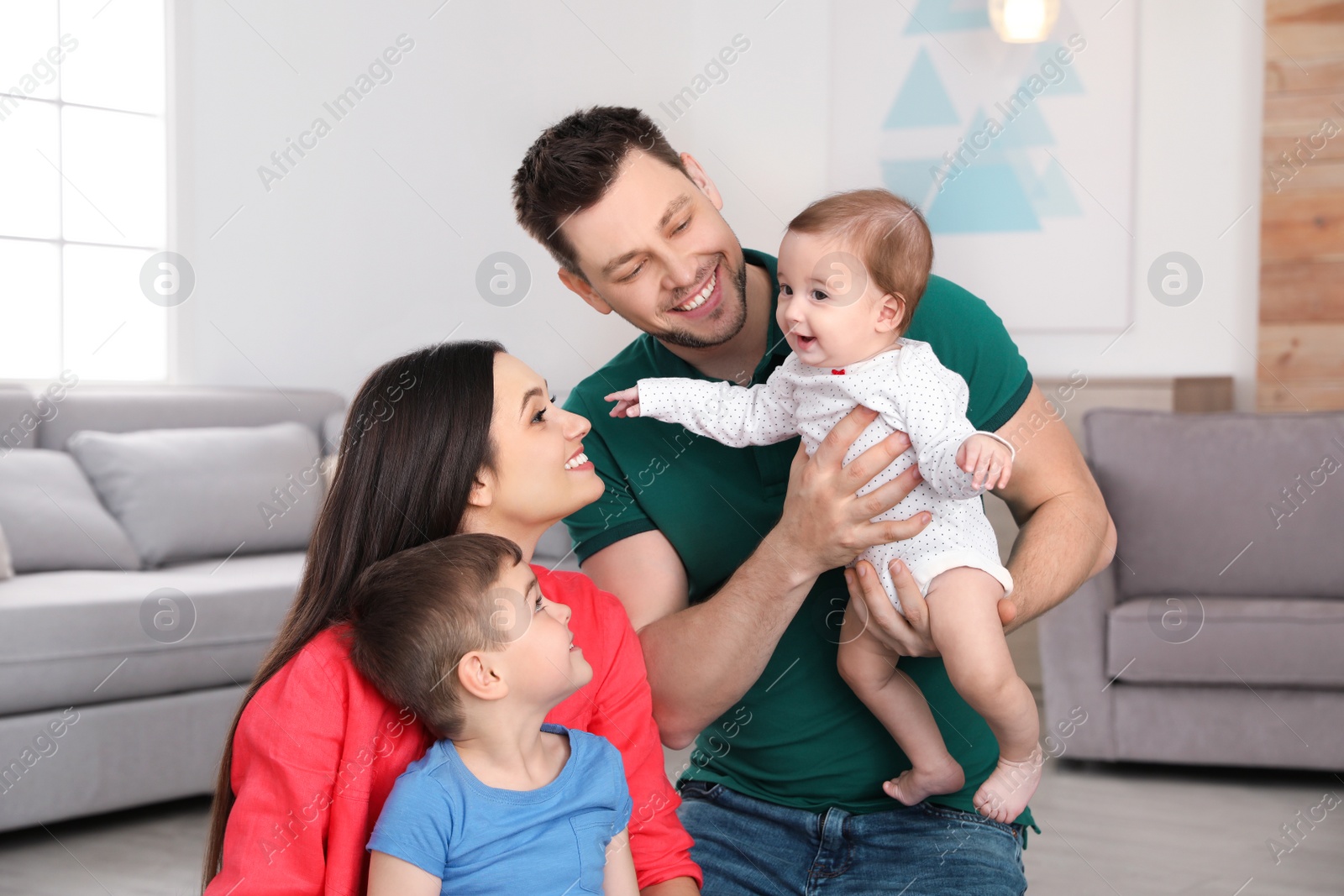 Photo of Portrait of happy parents and their cute children at home. Family time