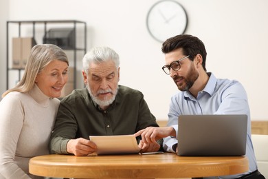 Notary consulting senior couple about Last Will and Testament in office