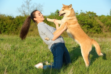 Photo of Young woman with adorable Akita Inu dog in park