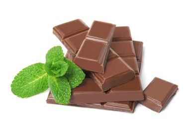 Tasty milk chocolate pieces with mint on white background