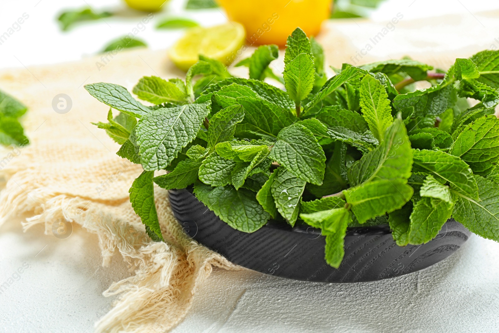 Photo of Wooden plate with fresh mint on table