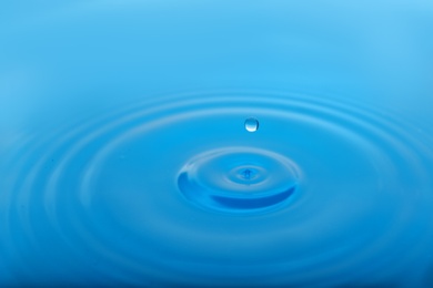 Photo of Splash of blue water with drop as background, closeup