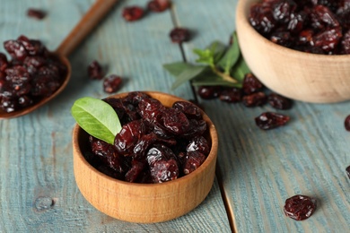 Photo of Tasty dried cranberries on blue wooden table