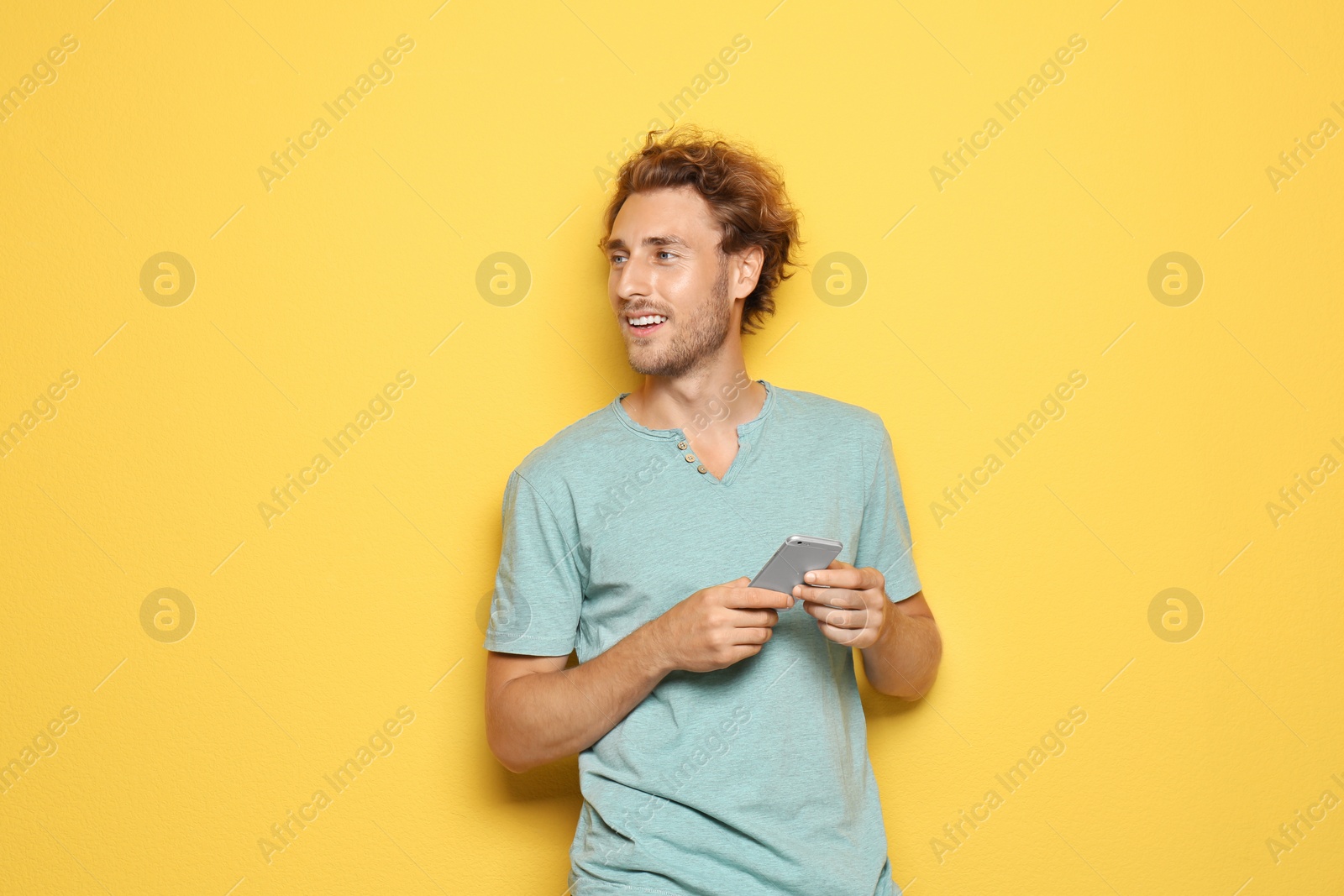 Photo of Young man with mobile phone on color background