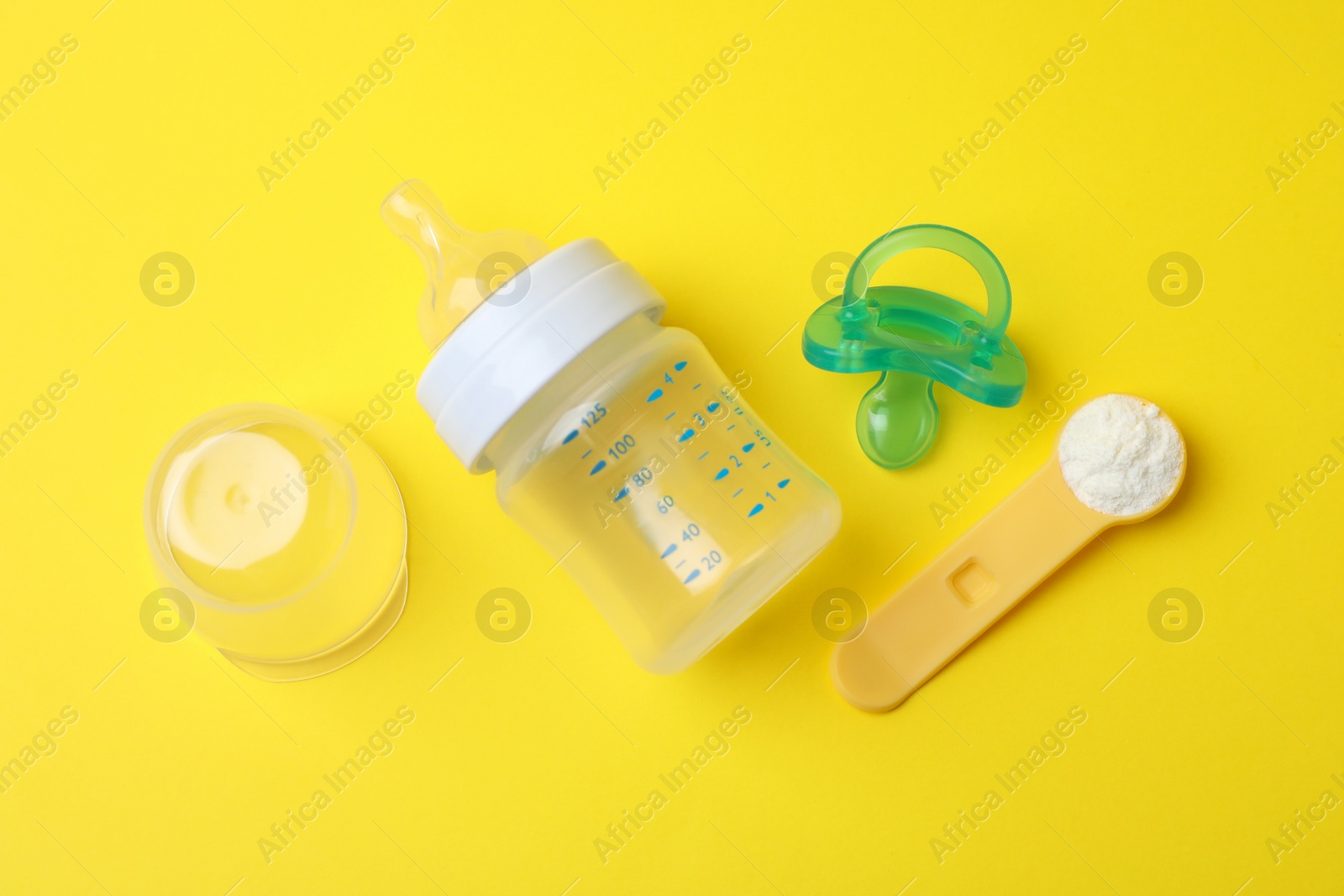 Photo of Flat lay composition with powdered infant formula on yellow background. Baby milk