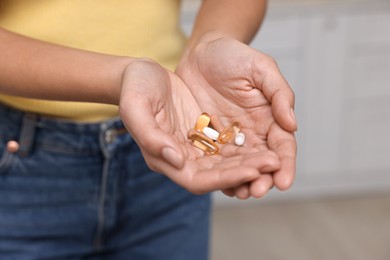 Photo of Woman with vitamin pills at home, closeup