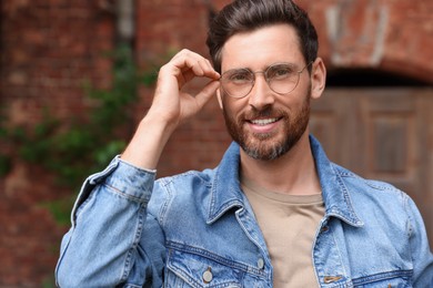 Photo of Smiling handsome bearded man with glasses outdoors