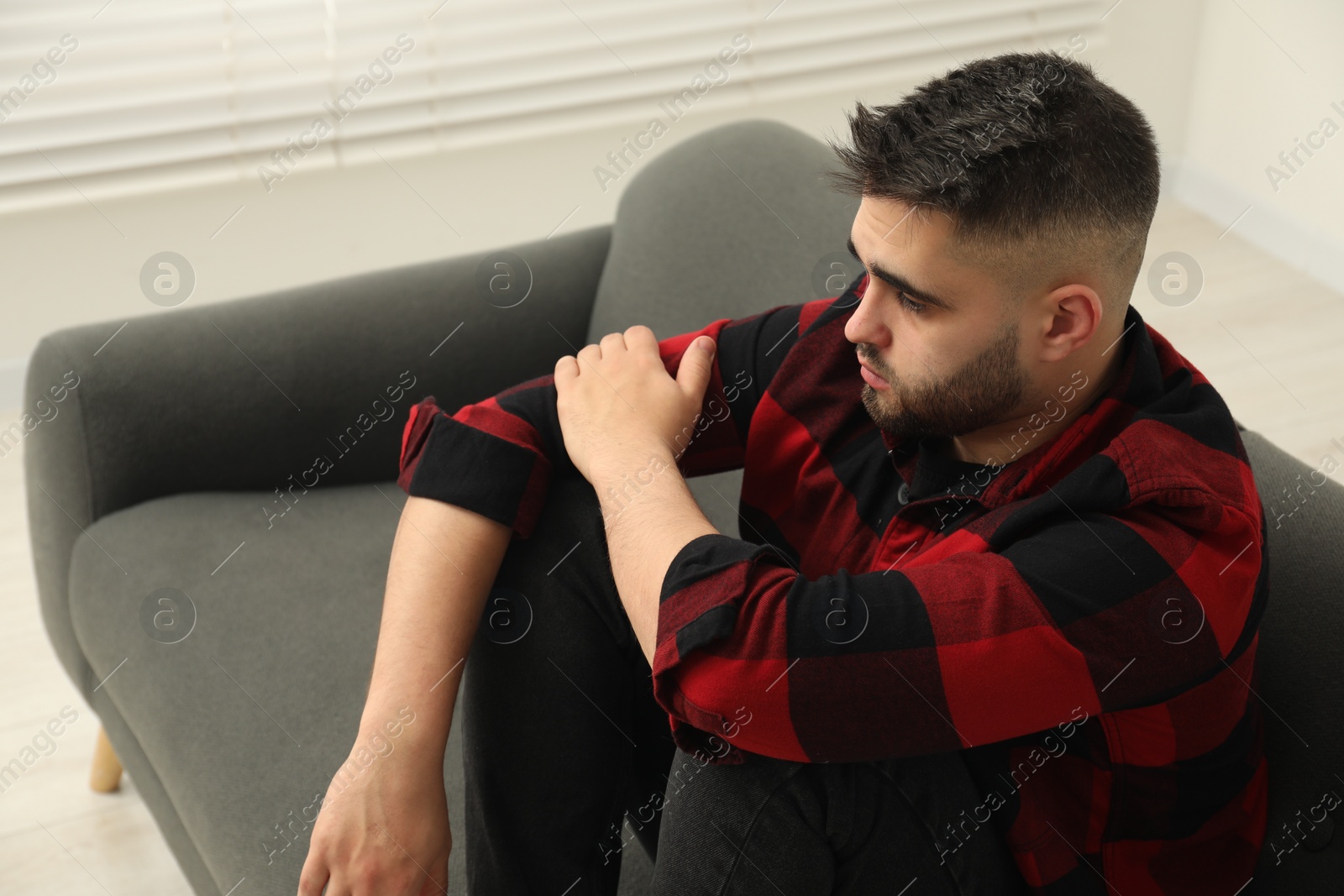 Photo of Sad lonely man on sofa at home