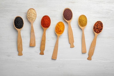 Photo of Flat lay composition with different aromatic spices in spoons on wooden background