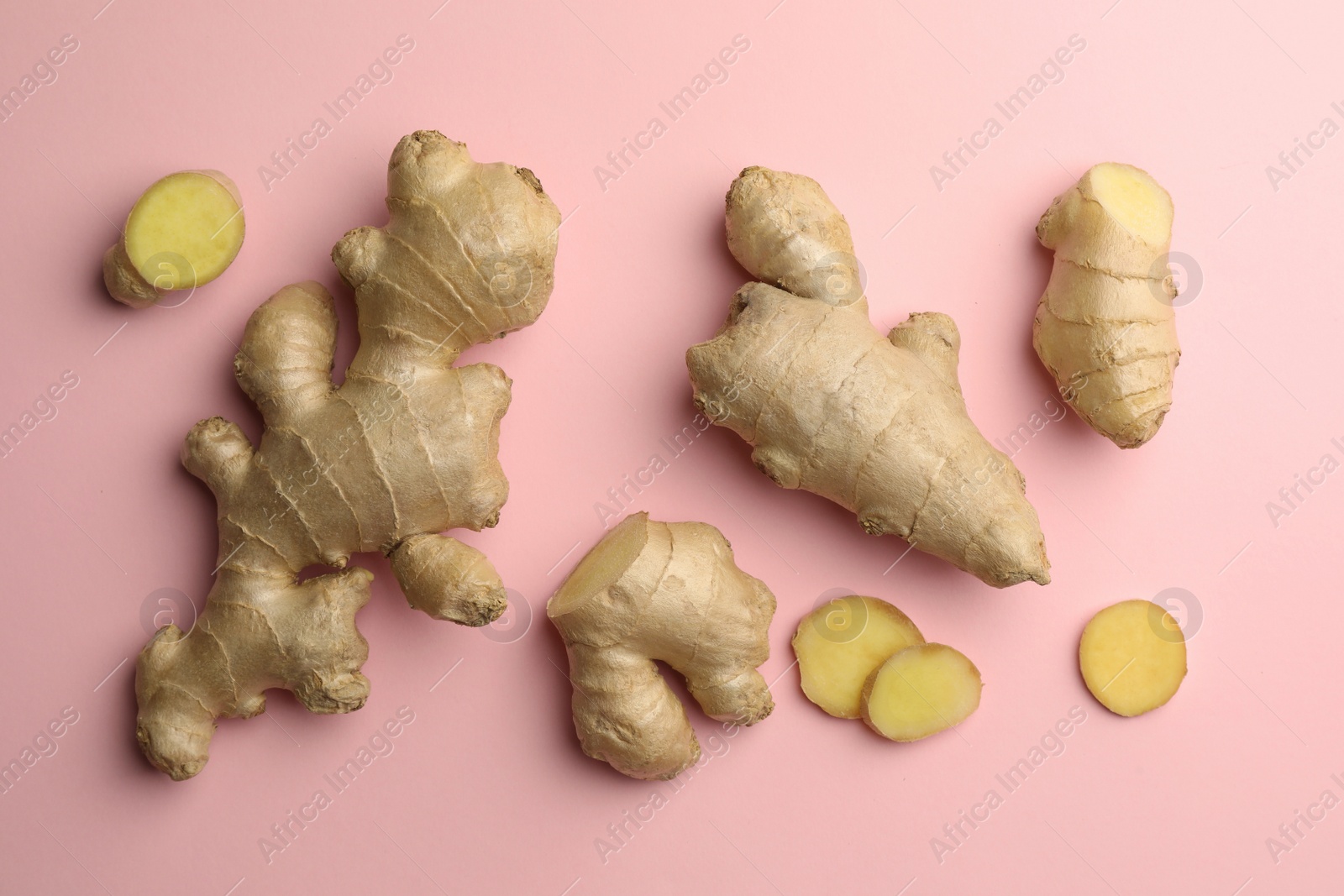 Photo of Fresh ginger on pale pink background, flat lay