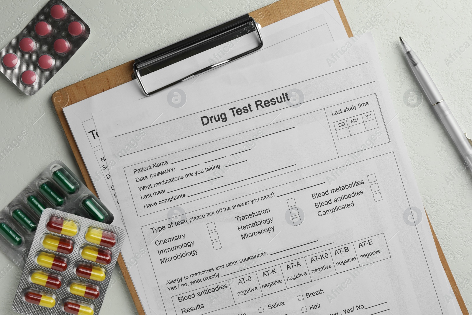 Photo of Drug test result form, pills and pen on light table, flat lay