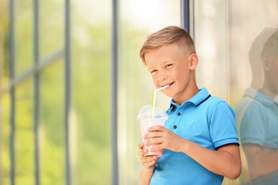 Photo of Little boy with cup of milk shake outdoors