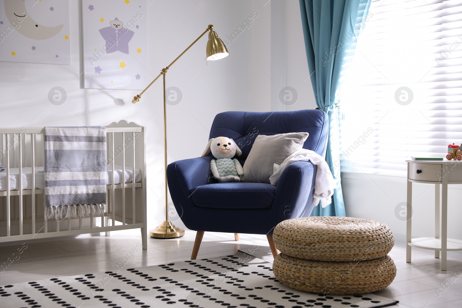 Photo of Cozy baby room interior with comfortable armchair