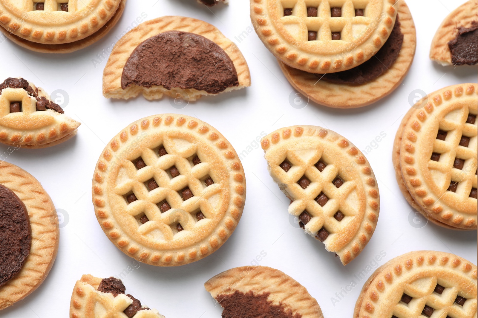 Photo of Tasty sandwich cookies with cream on white background, flat lay