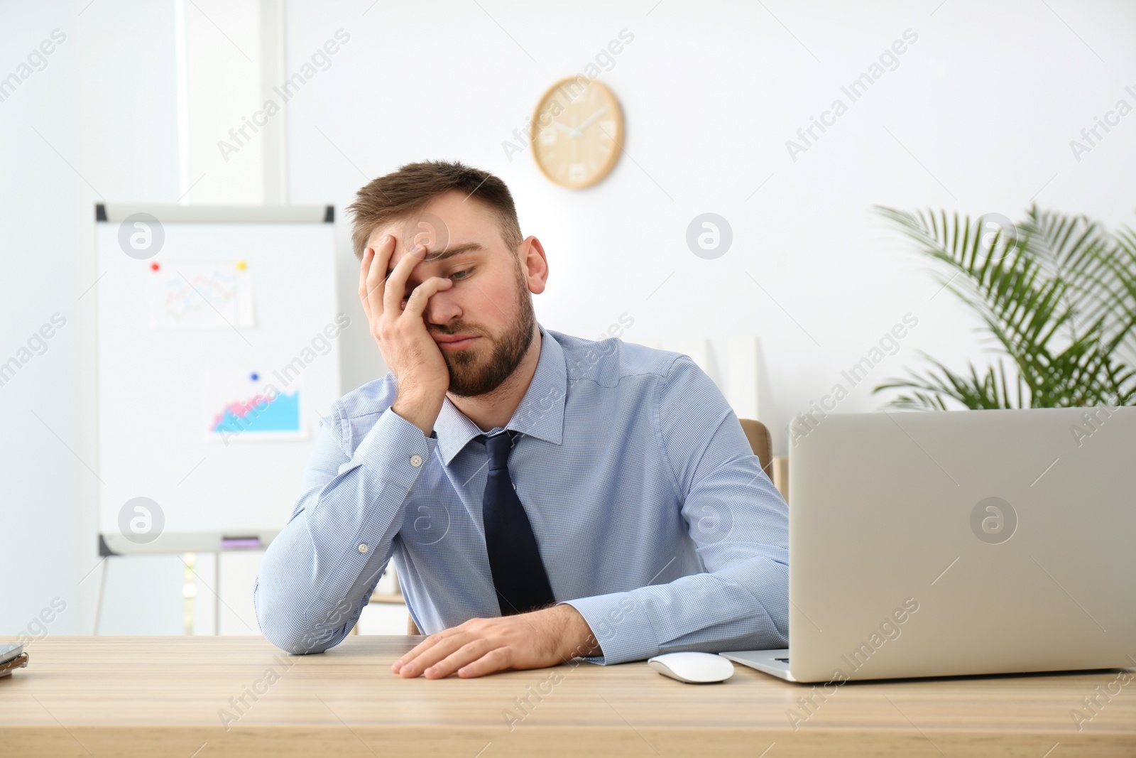 Photo of Lazy young office employee procrastinating at workplace