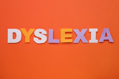 Word Dyslexia made of paper letters on orange background, flat lay