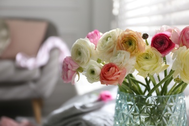 Photo of Beautiful ranunculus flowers in vase indoors, closeup. Space for text