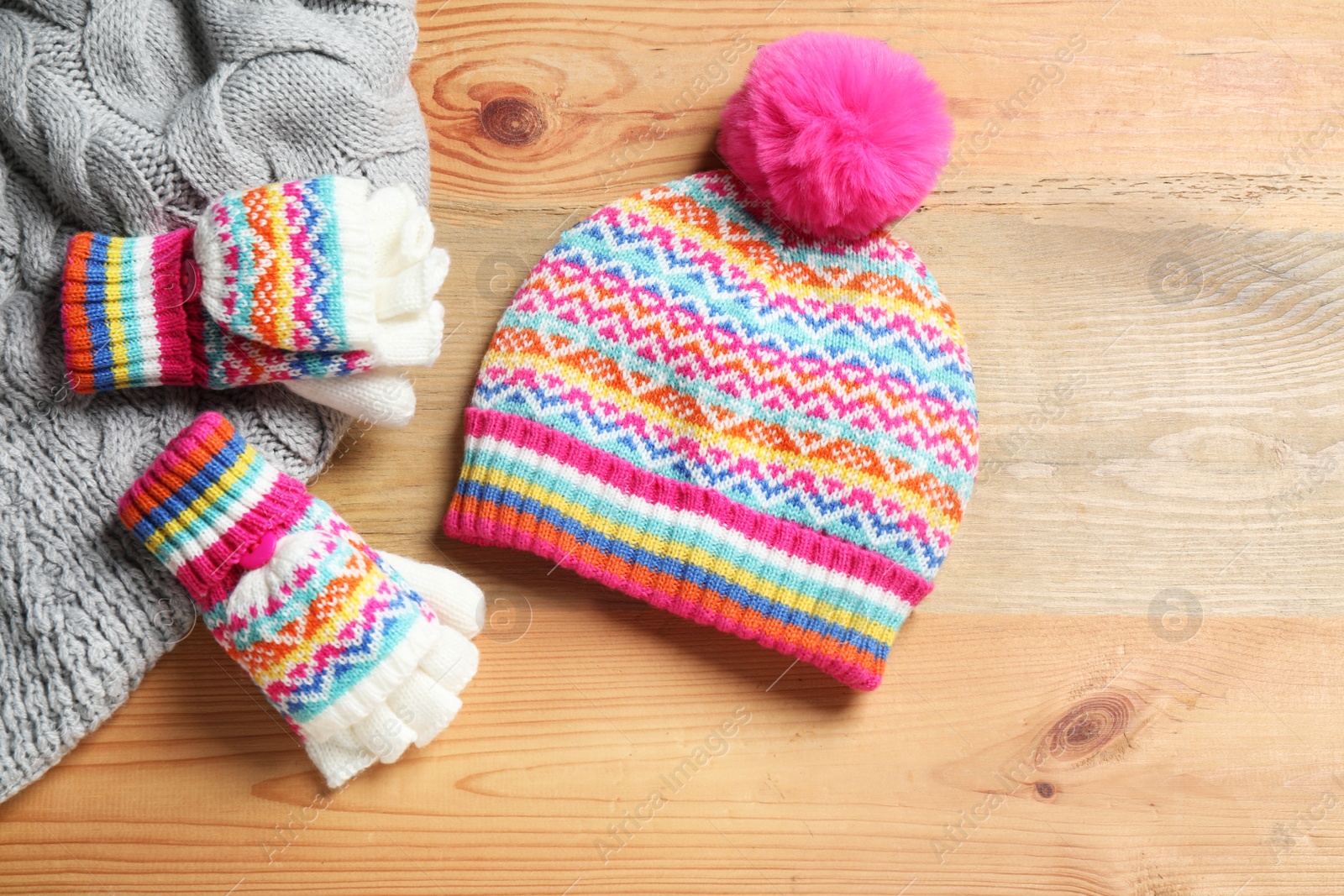 Photo of Warm knitted clothes on wooden background, flat lay