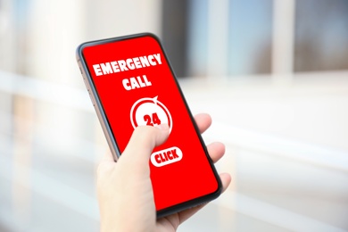Hotline service. Woman making emergency call via smartphone outdoors, closeup