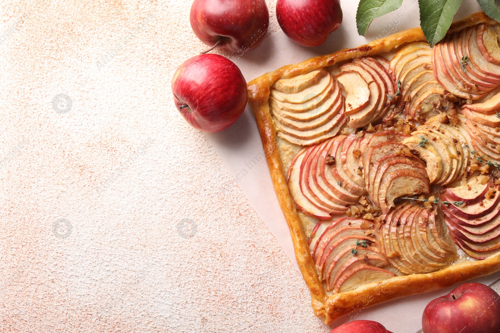 Photo of Tasty apple pie with nuts and fresh fruits on beige textured table, flat lay. Space for text