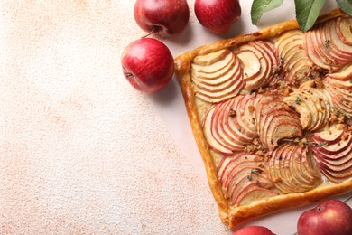 Tasty apple pie with nuts and fresh fruits on beige textured table, flat lay. Space for text