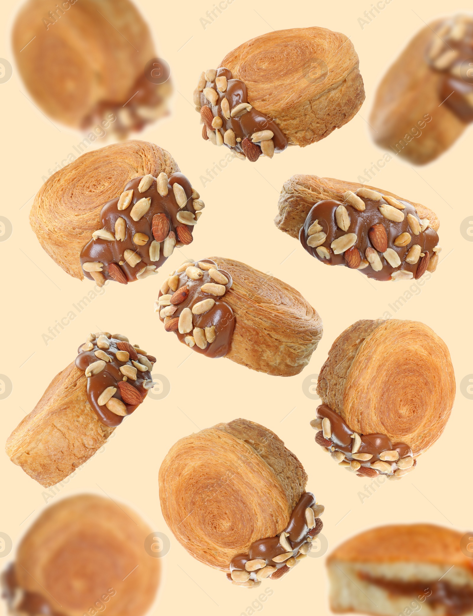 Image of Delicious round croissants in air on beige background. Puff pastry