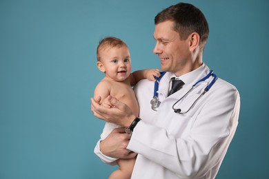 Photo of Pediatrician with cute little baby on light blue background. Space for text