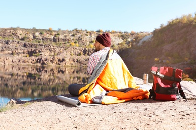 Photo of Male camper with sleeping bag in wilderness