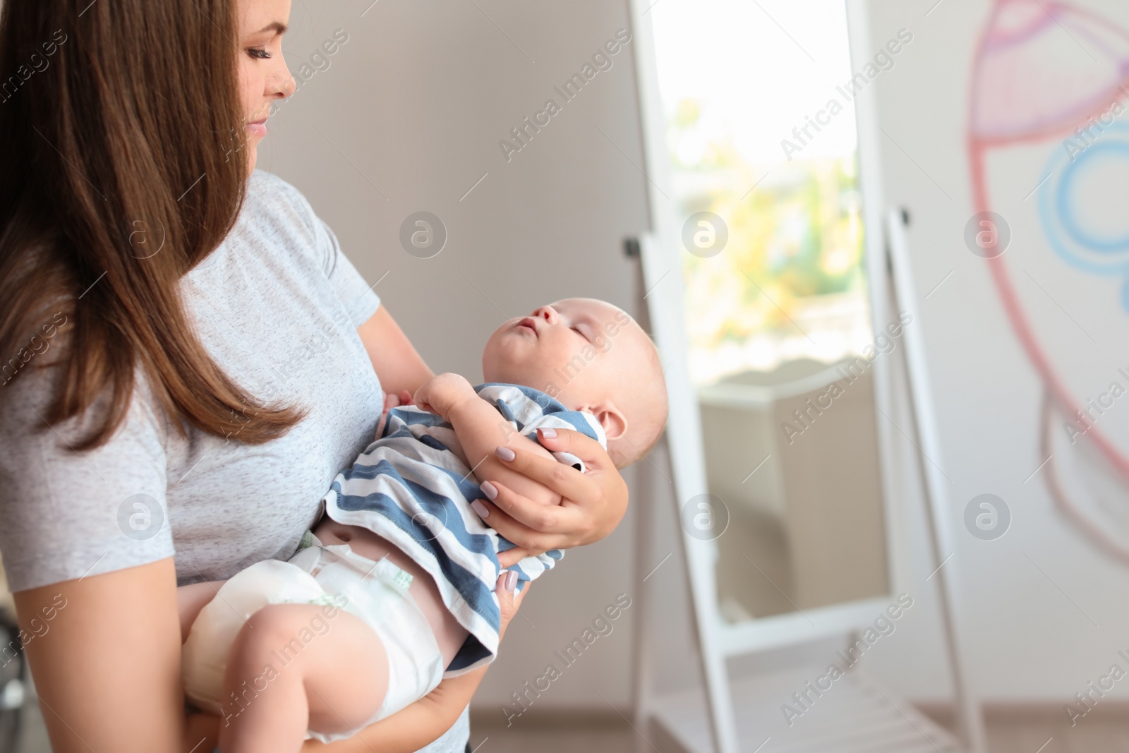 Photo of Mother with her sleeping baby at home