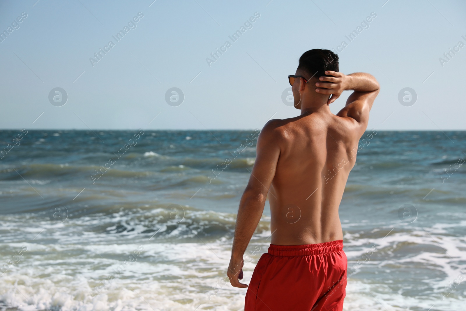 Photo of Man with attractive body on beach. Space for text