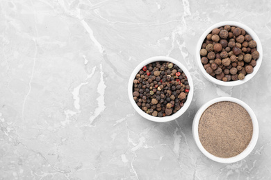 Ground pepper and corns on grey table, flat lay.  Space for text