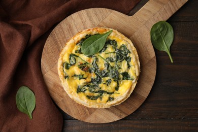 Photo of Delicious pie with spinach on wooden table, top view