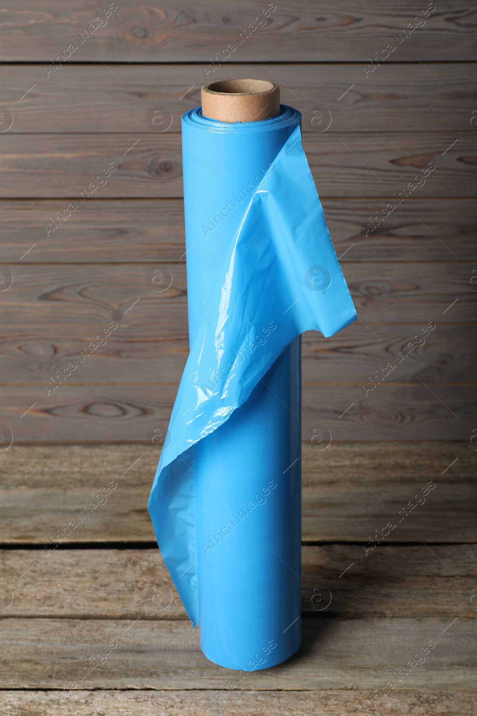 Photo of Roll of plastic stretch wrap film on wooden table