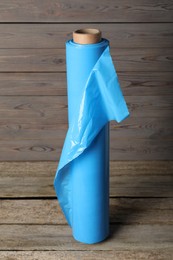 Photo of Roll of plastic stretch wrap film on wooden table
