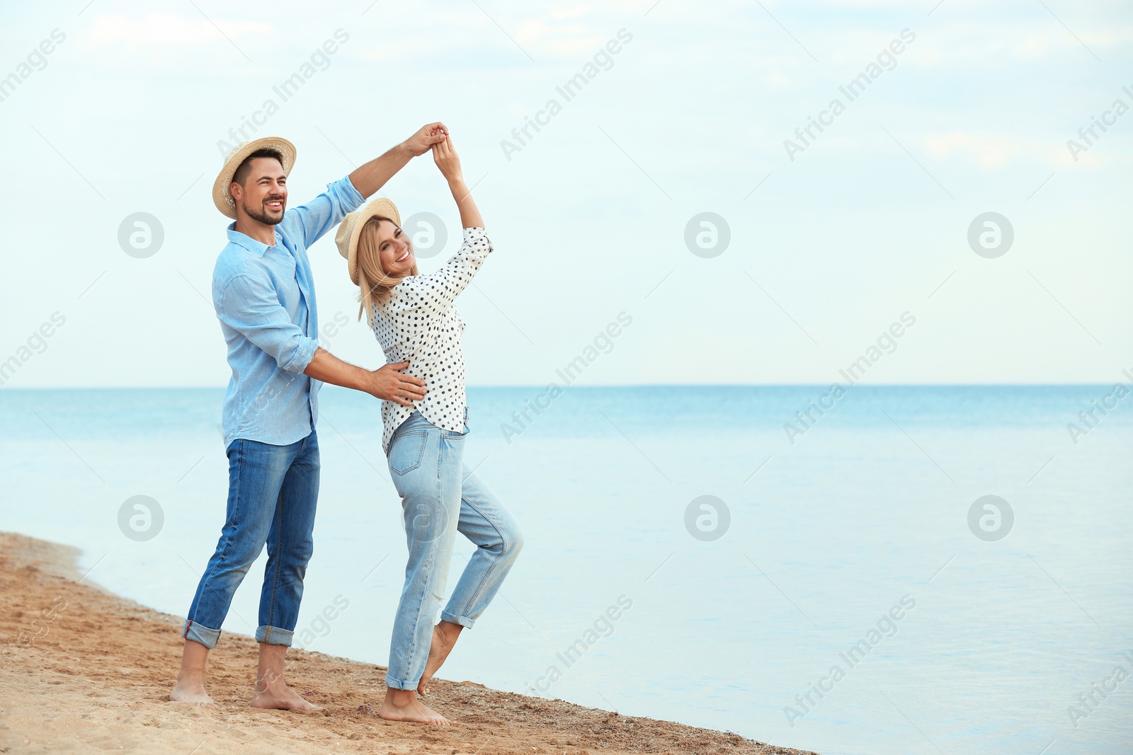 Photo of Happy romantic couple dancing on beach, space for text