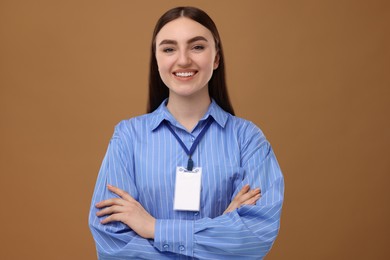 Happy woman with blank badge on brown background