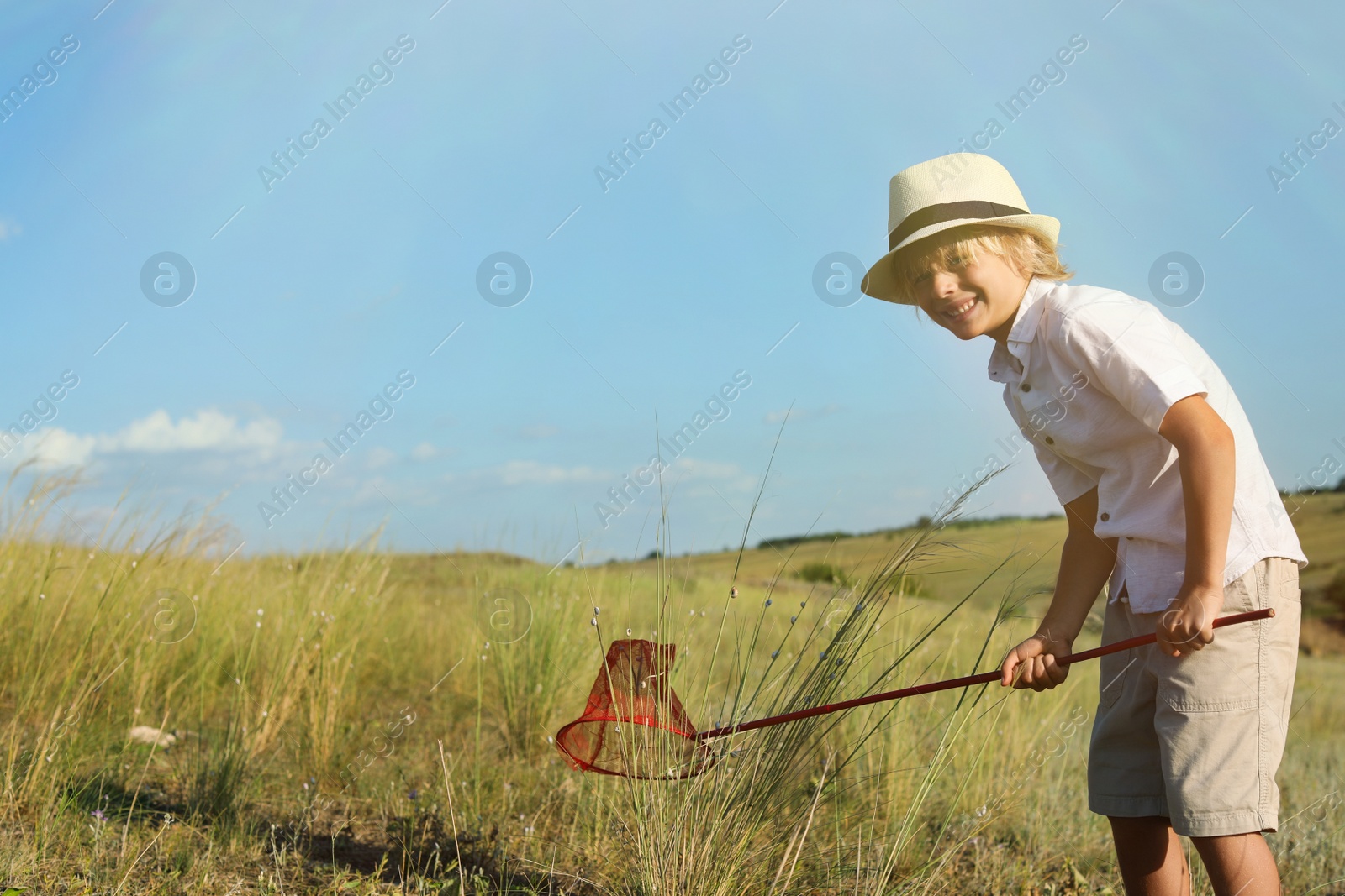 Photo of Cute little boy with butterfly net outdoors, space for text. Child spending time in nature