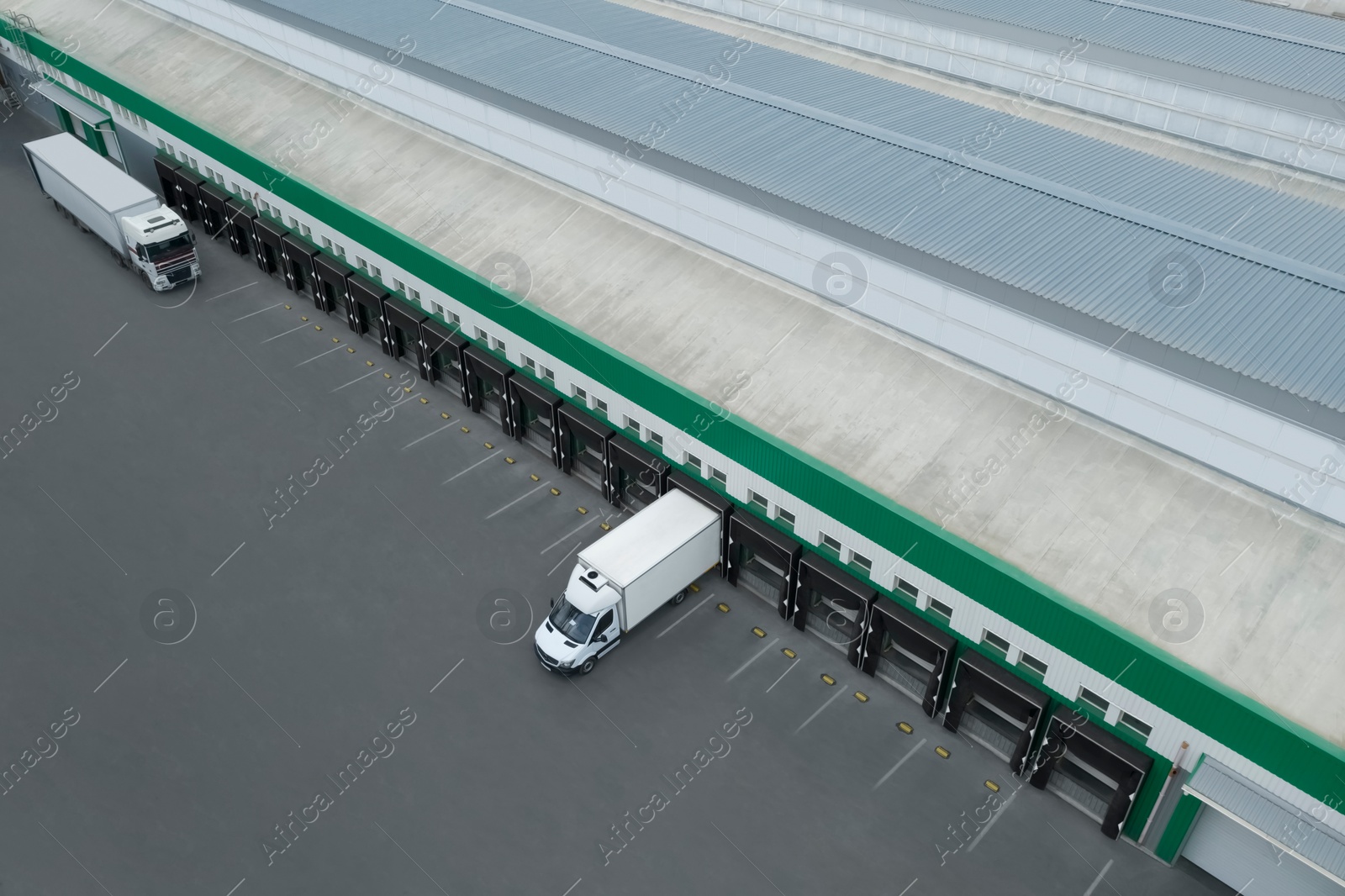 Image of Trucks near warehouse outdoors, aerial view. Logistics center