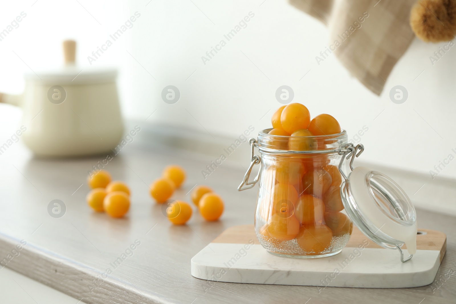 Photo of Pickling jar with fresh tomatoes on counter in kitchen. Space for text